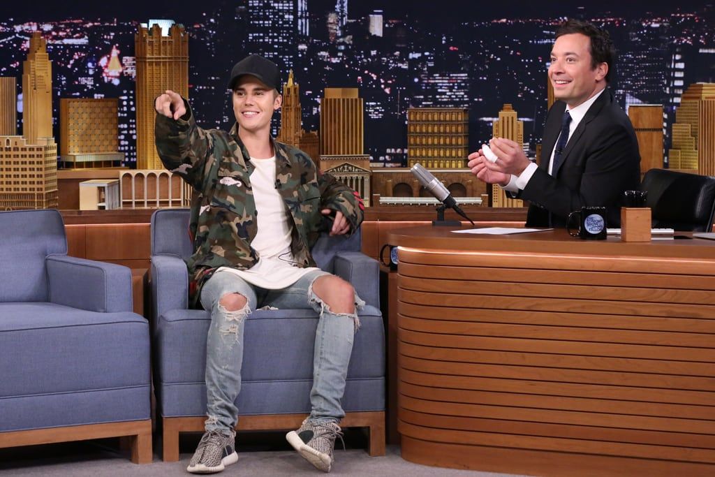 Justin Bieber wore Yeezys on Fallon three days after crying at the VMAs. Justin Bieber on the Tonight Show couch next to Jimmy Fallon, Off-White camo jacket, ripped jeans, Yeezy Boost 350 Turtle Dove with the black suede YZY panel showing, New York, 2 Sep 2015.