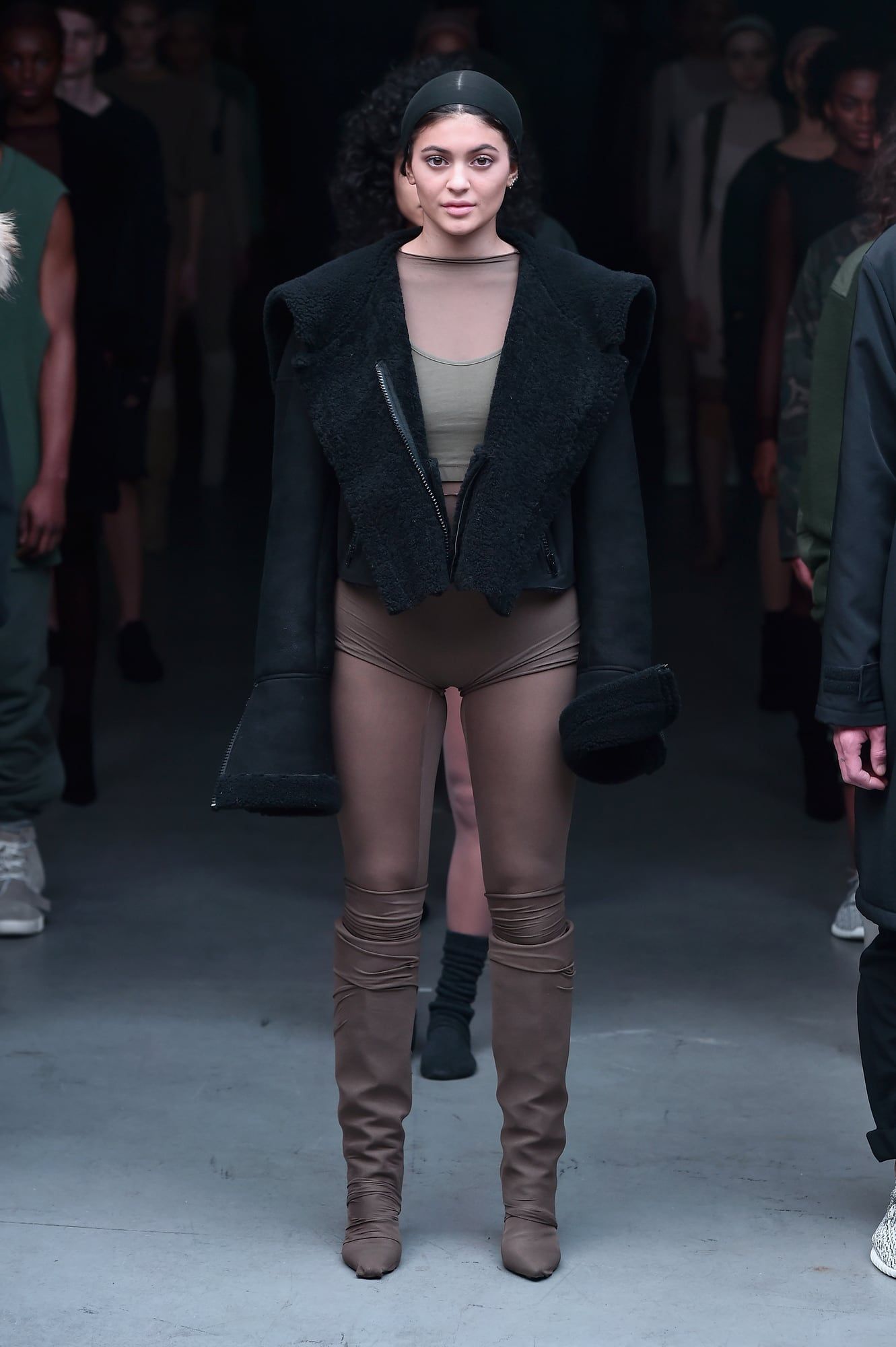 Kylie Jenner walked Yeezy Season 1. A year later, Ye lost her to Puma. Kylie Jenner full length on the Yeezy Season 1 runway: black shearling jacket, skull cap, sheer nude top over khaki, nude knickers and tights, caramel knee boots. Skylight Clarkson Sq, New York, 12 Feb 2015.