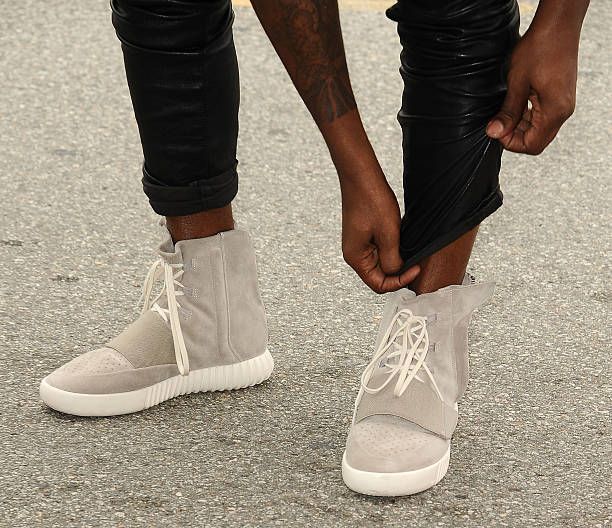 Ye tugged up his cuffs at a Grammy brunch to show the first adidas Yeezy. Ye pulling up his trouser cuffs to show the 750 Boost, Roc Nation Grammy brunch, Beverly Hills, 7 Feb 2015.