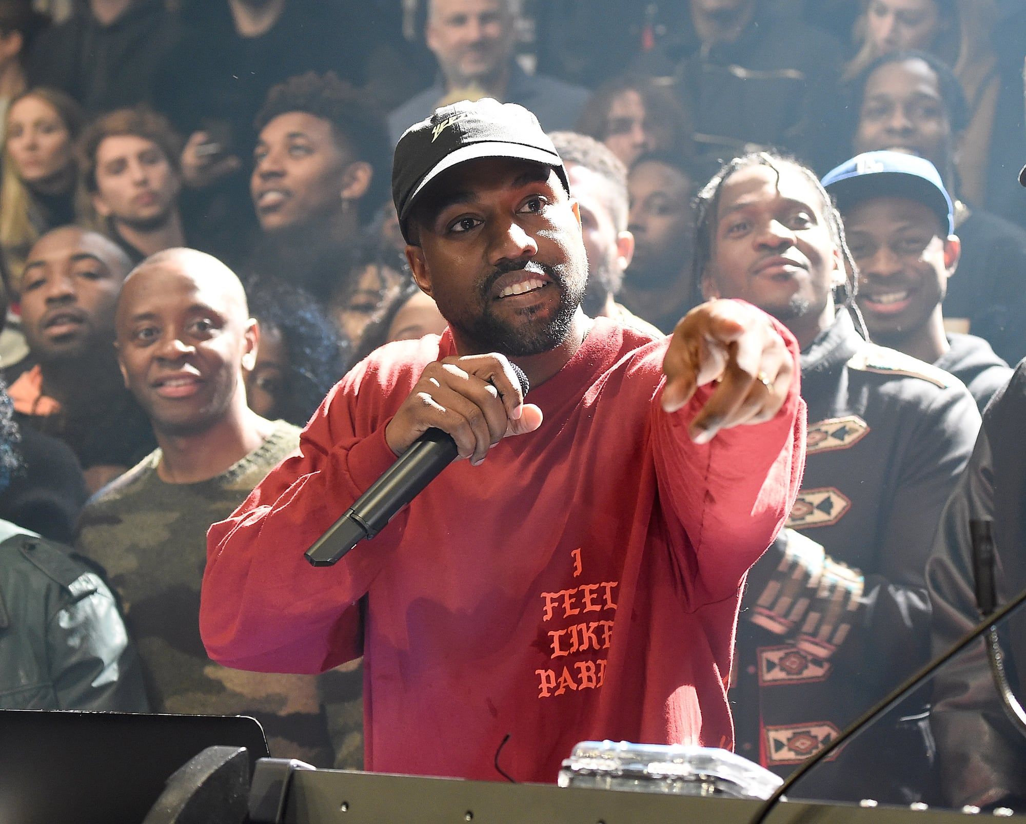 Ye sold out Madison Square Garden with an album nobody had heard. Ye at the mic on the arena floor in the maroon 'I feel like Pablo' long sleeve and black Yeezus cap, Pusha T behind him, Madison Square Garden, 11 Feb 2016.