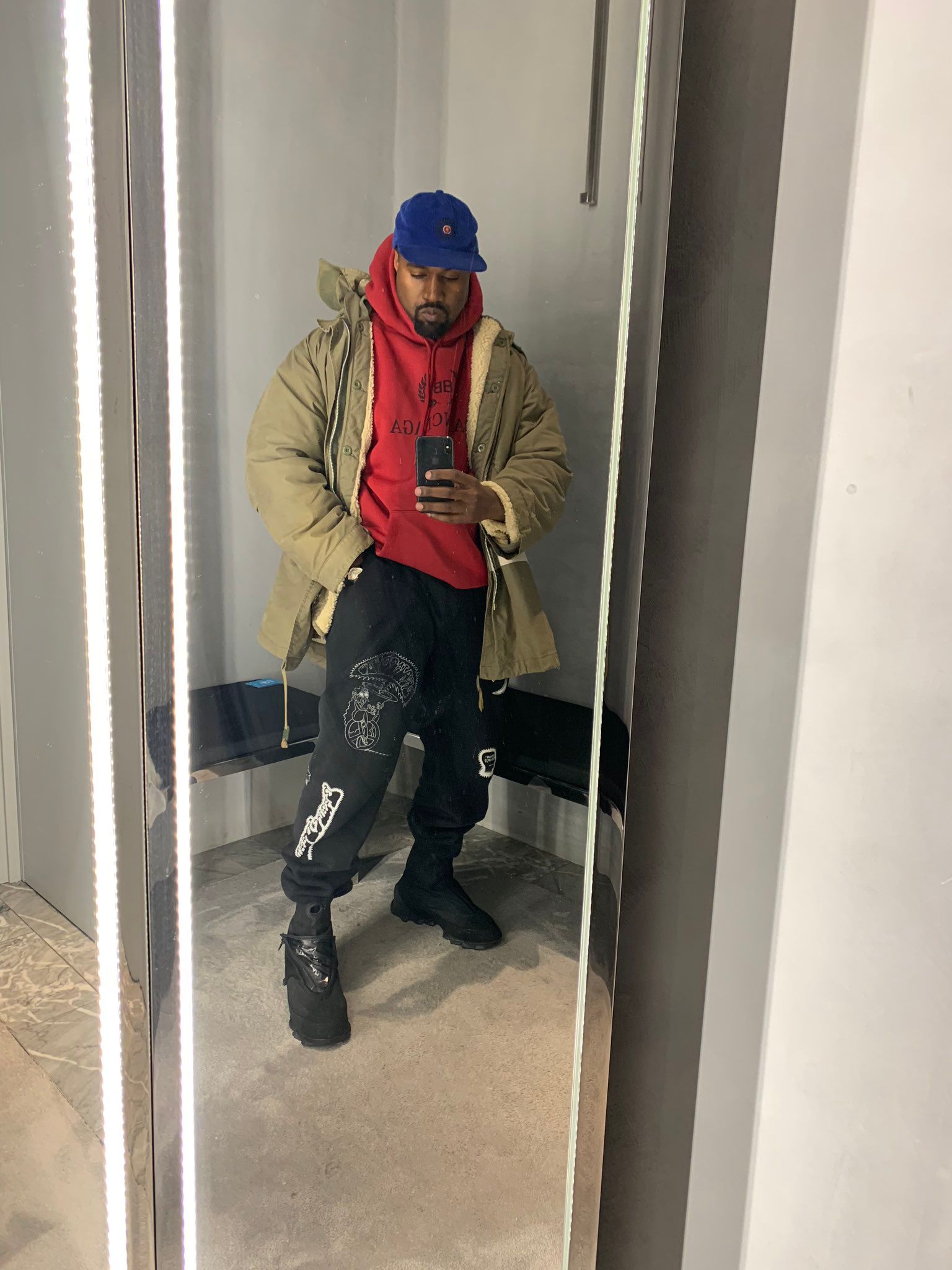 Ye’s mirror selfie was about his joggers. Everyone zoomed in on the boots.. Ye's mirror selfie, 14 Dec 2018: khaki parka, red hoodie, blue cap, black joggers and the black boots.