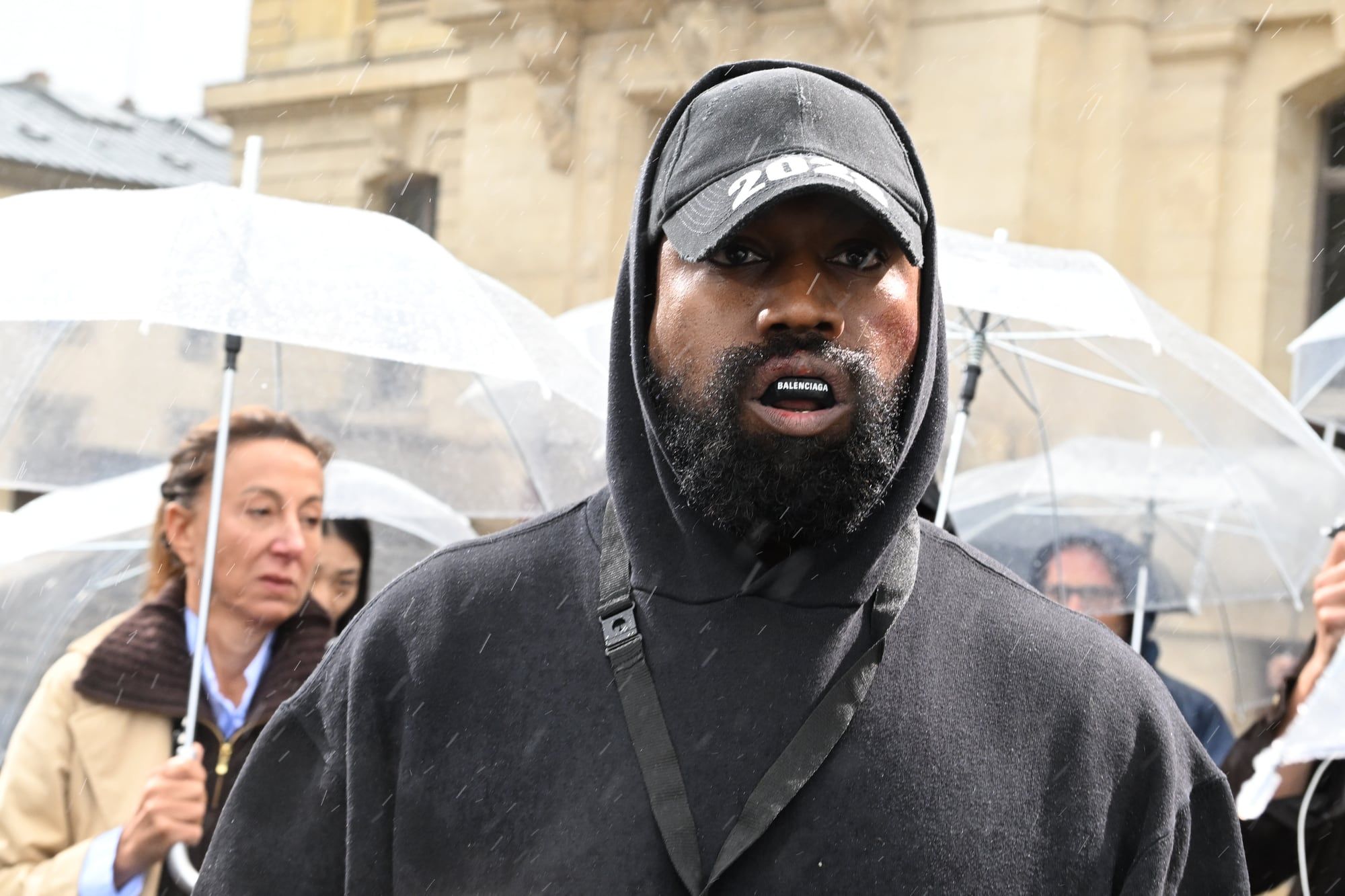 Ye lost Balenciaga, CAA, Gap and adidas in five days of October 2022. Ye hooded, in the rain, arriving at Balenciaga's show in Paris, 2 Oct 2022.
