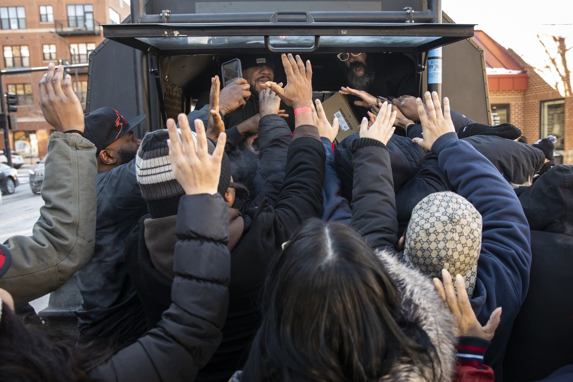 Ye teased a Yeezy basketball shoe in 2018. It arrived by truck in 2020. Fans reaching for free pairs of the Quantum at a Yeezy truck near the United Center, Chicago, 14 Feb 2020.
