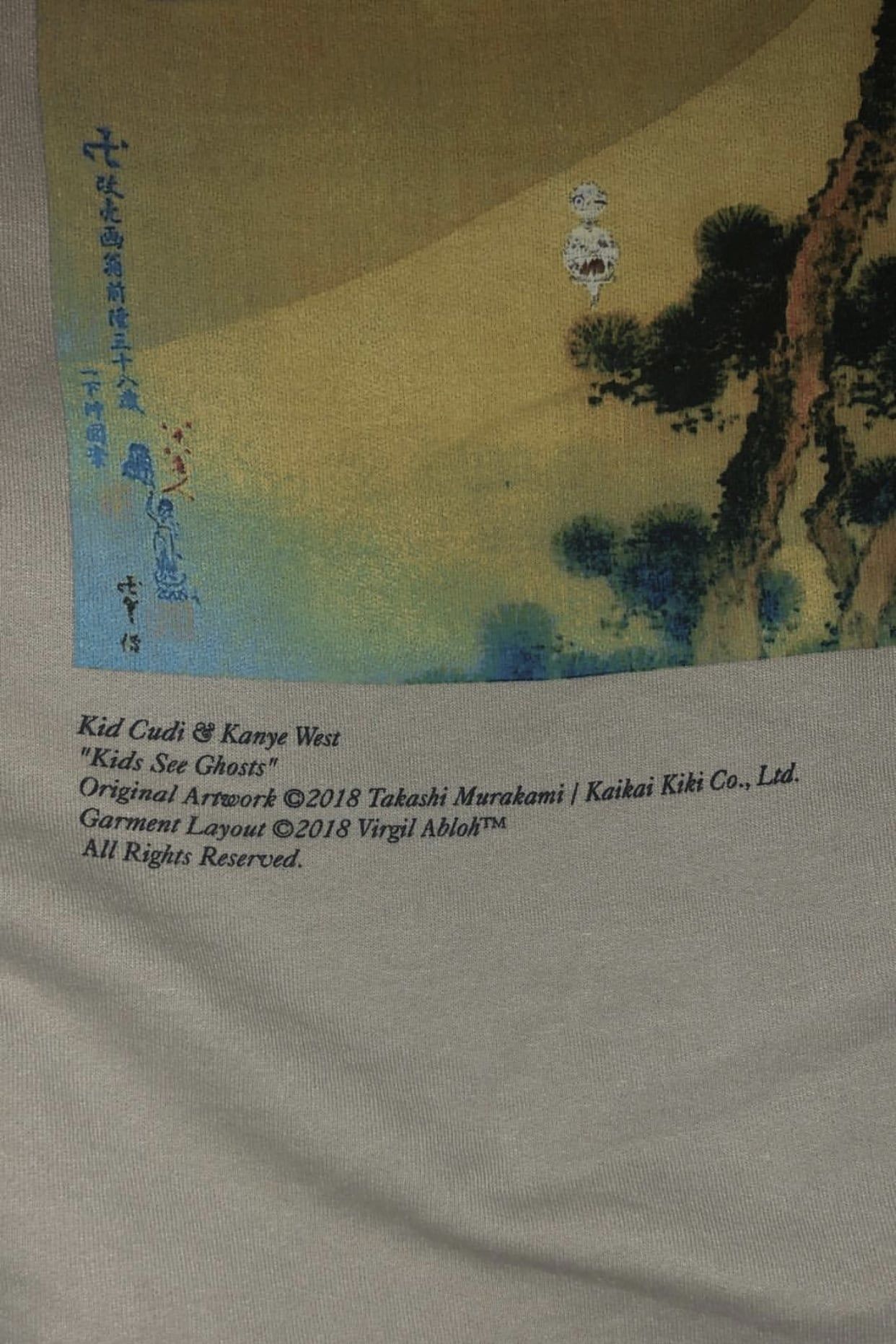 The Kids See Ghosts hoodie prints its own credits: Murakami’s art, Virgil’s layout. The credit line under the print: Original Artwork ©2018 Takashi Murakami / Kaikai Kiki Co., Ltd. Garment Layout ©2018 Virgil Abloh.