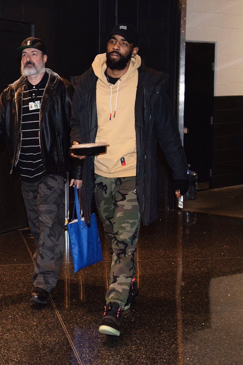 Kyrie Irving had his own Nike shoe and still walked in wearing Air Yeezy 2s. Kyrie Irving arriving at TD Garden in a tan hoodie and camo trousers, Nike Air Yeezy 2 Black/Solar Red, Boston, 16 Jan 2019.