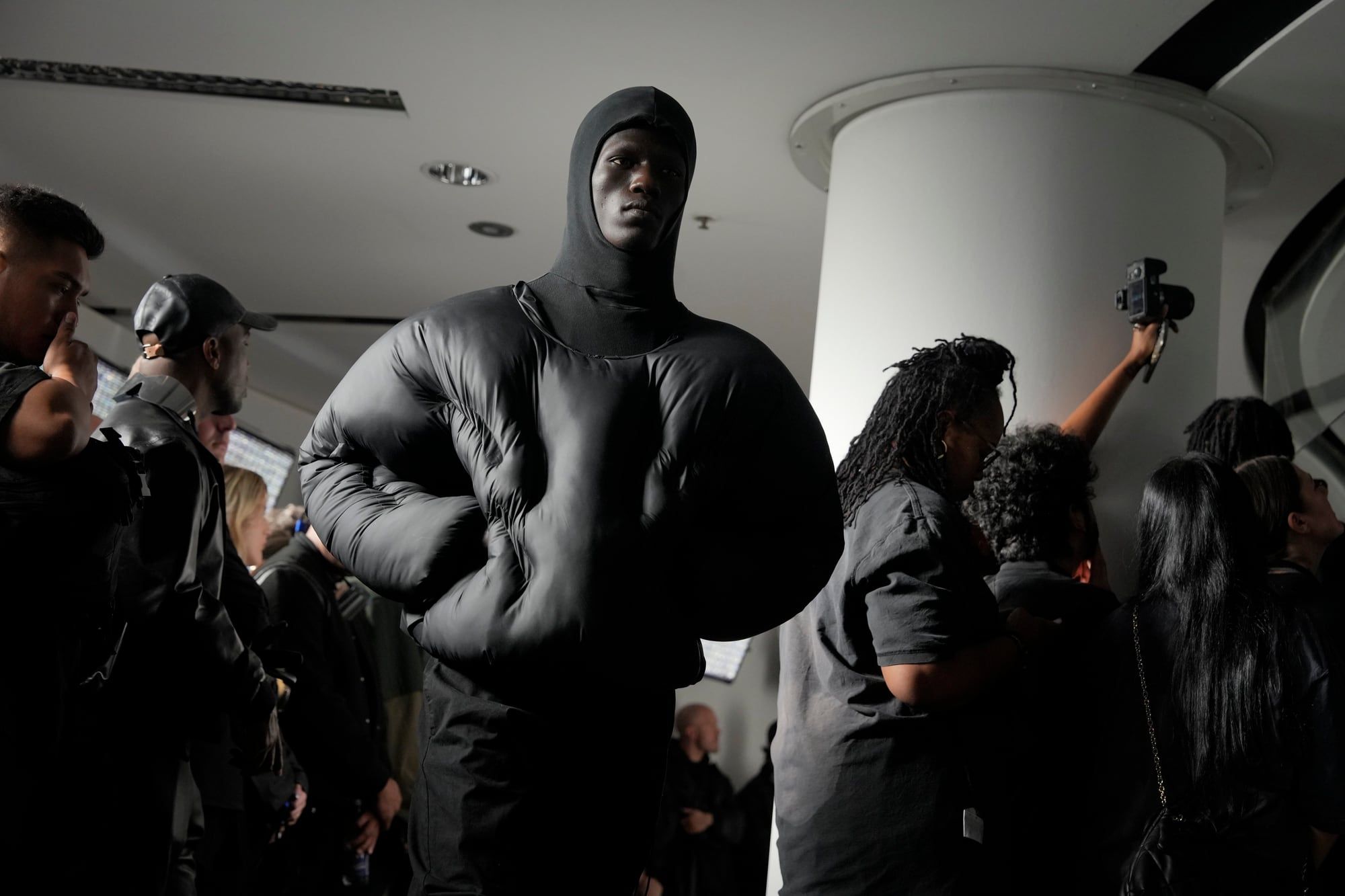 Ye gatecrashed Paris Fashion Week with YZY SZN 9 and a “White Lives Matter” shirt. A hooded look in a black puffer walking through the crowd.