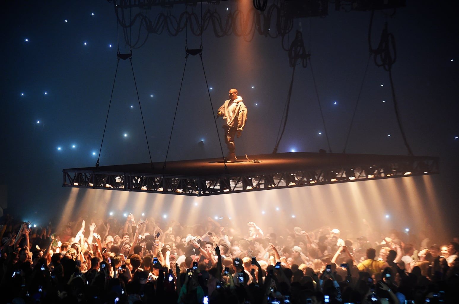 Ye’s Saint Pablo Tour had no stage, just a platform floating over the crowd. The floating platform over the Madison Square Garden floor, 5 Sep 2016, Ye in the same jacket and hoodie.