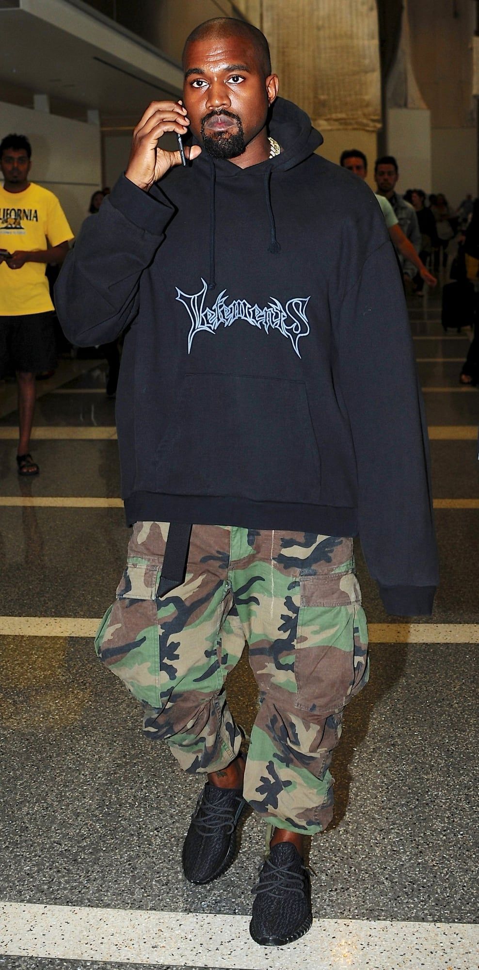 Ye wore the 350 Turtle Dove four weeks early, then again in black. Pirate Black on Ye, full length, Vetements hoodie and camo cargos, arriving at LAX, 6 Jul 2015.