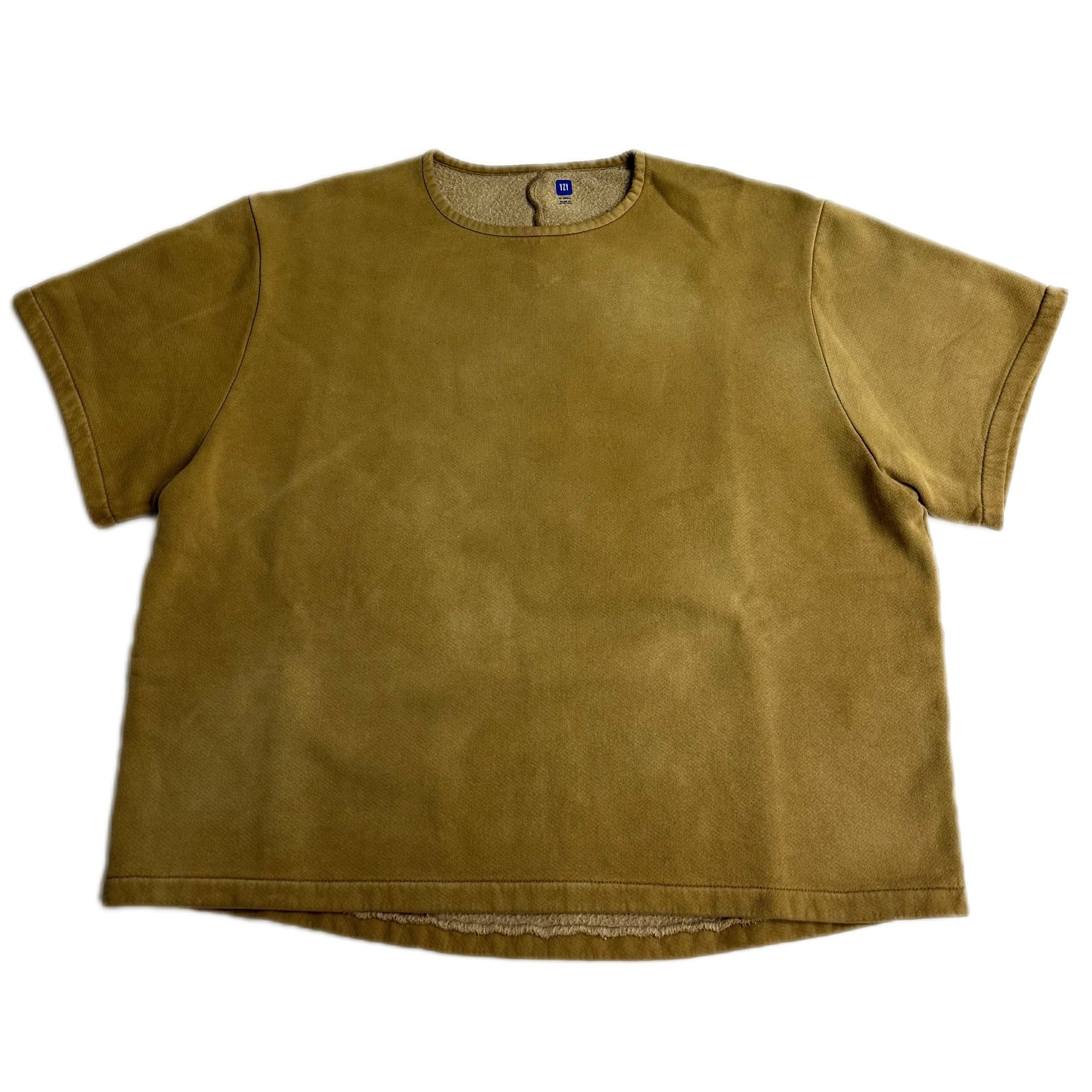 Gap never sold Yeezy Gap’s fleece yoke tee. StockX still calls it Balenciaga. Bronze, front, blue YZY tab at the neck.