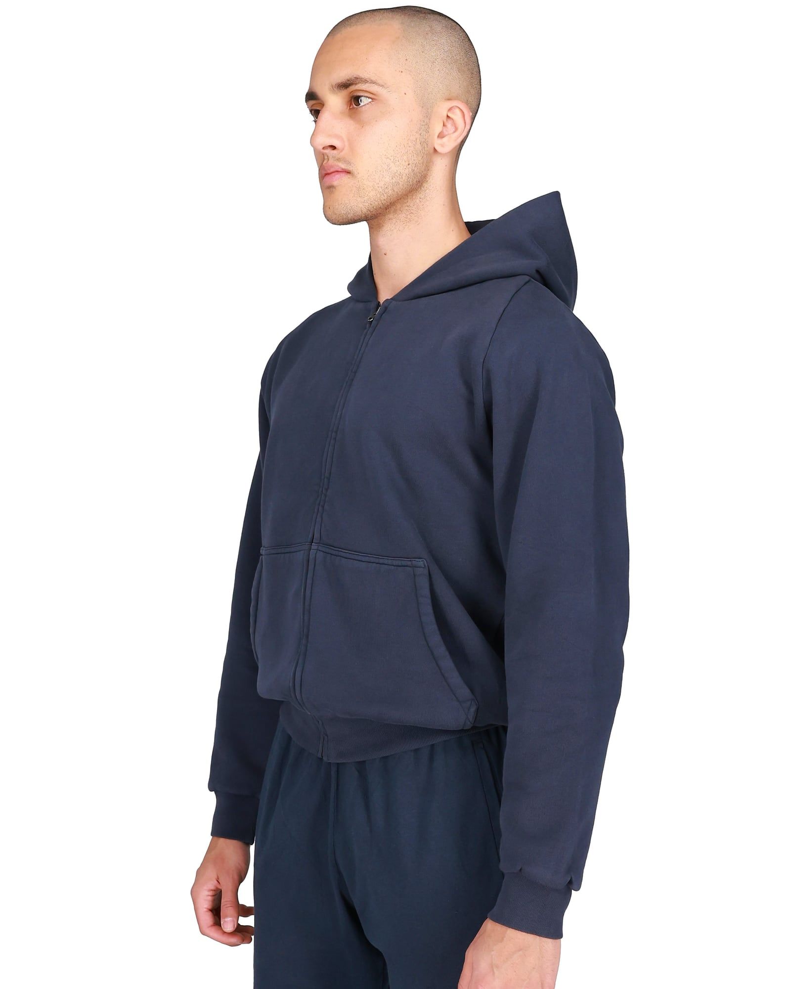 The Yeezy Gap zip-up missed Gap entirely and sold out on yeezy.com. Navy, three-quarter view on a model: zip through the pouch pocket, ribbed cuffs and hem.