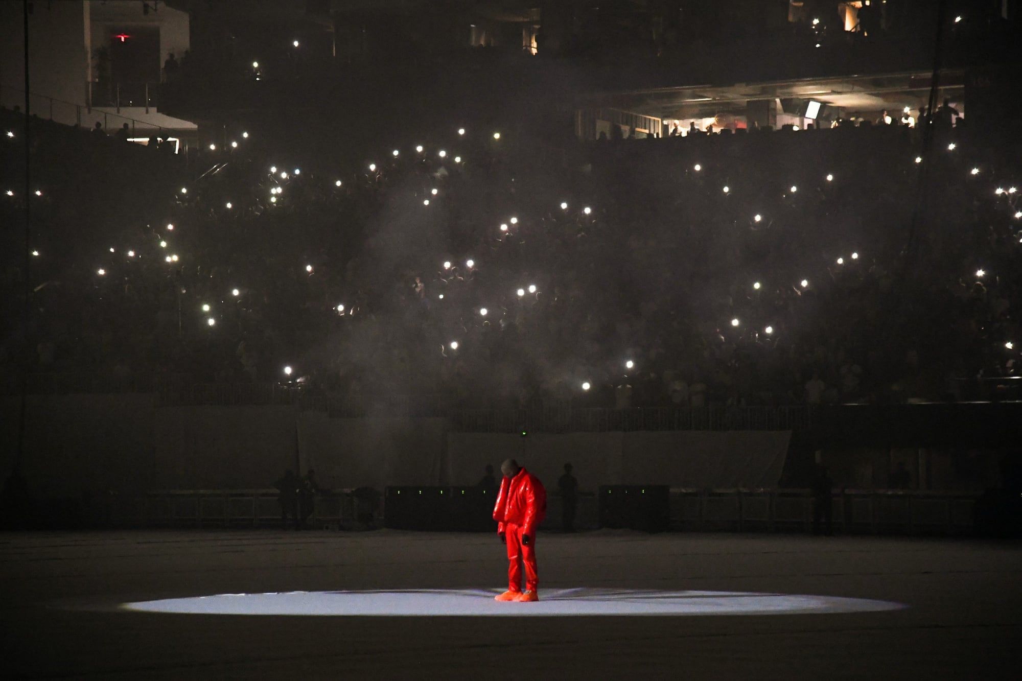 Ye wore all three Round Jacket colours before Gap put them on sale. Ye in the spotlight on the stadium floor, Atlanta, 22 Jul 2021.