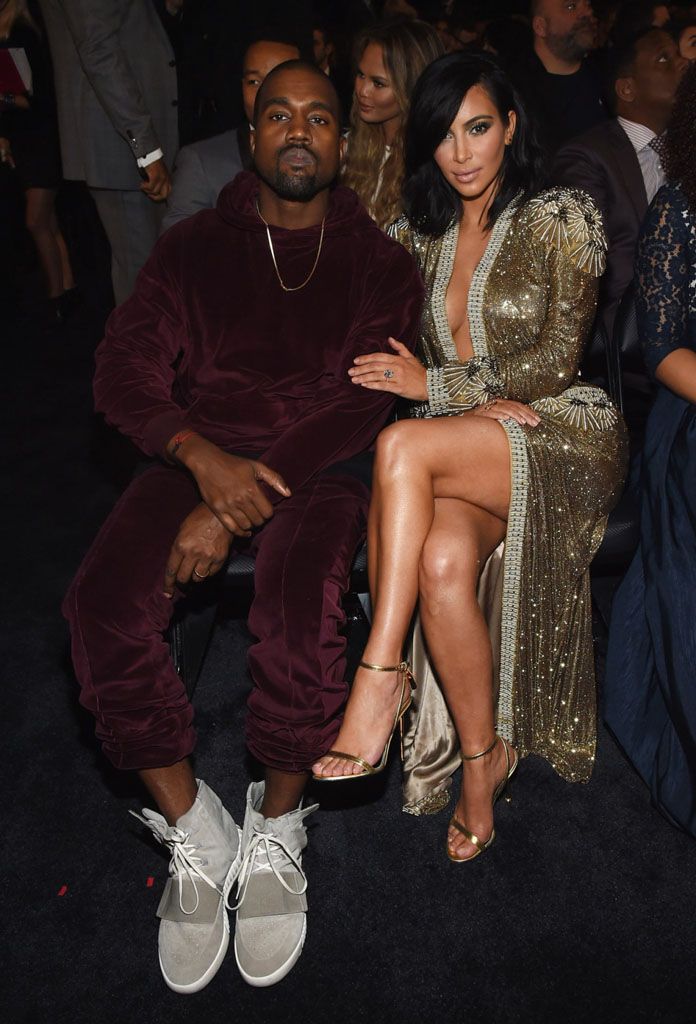 Ye tugged up his cuffs at a Grammy brunch to show the first adidas Yeezy. Ye in the 750 Boost with a burgundy velour tracksuit, seated with Kim Kardashian at the 57th Grammy Awards, Staples Center, Los Angeles, 8 Feb 2015, the day after the brunch.