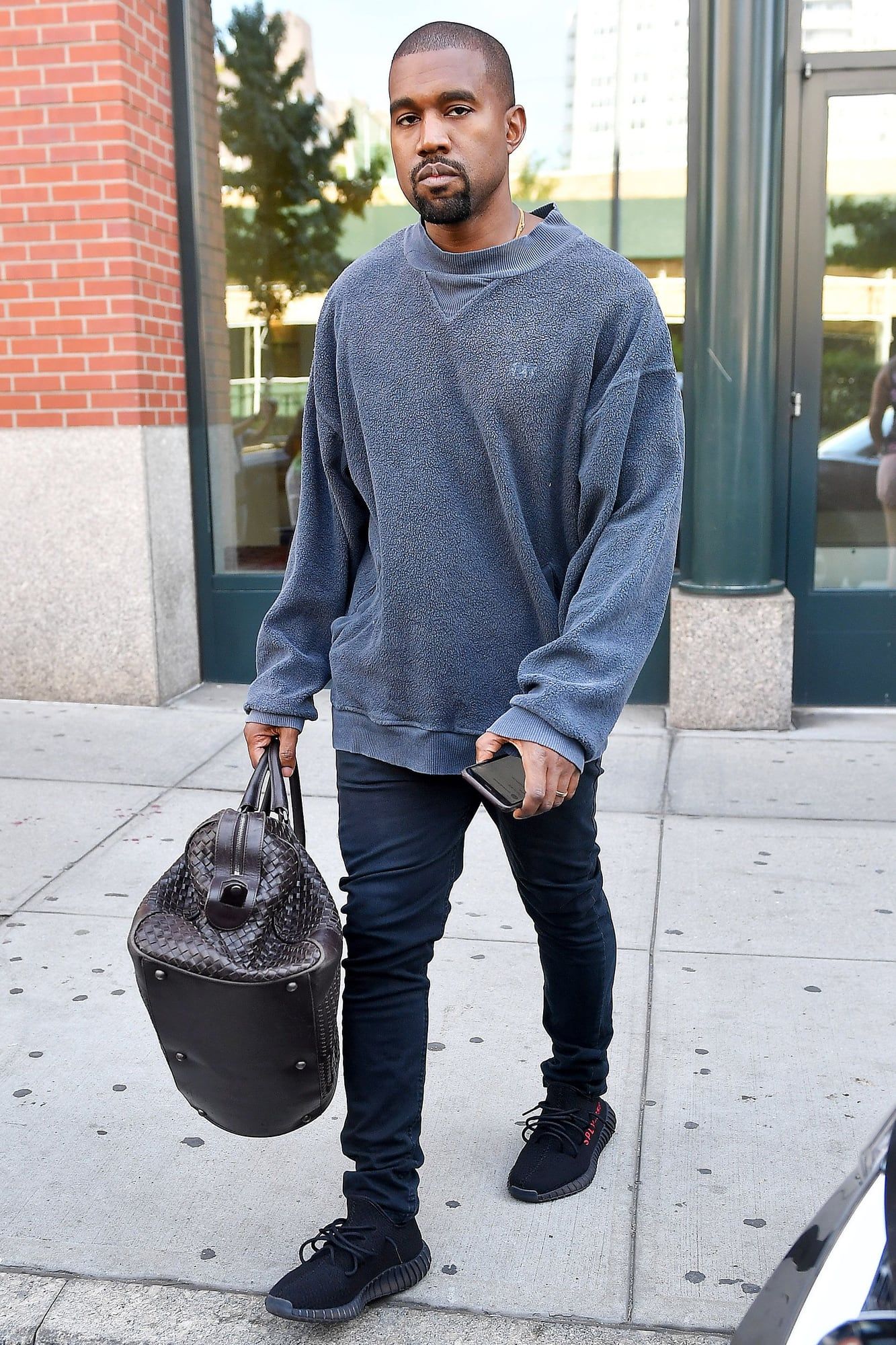 The black 350 V2 lost a little more of its stripe every time. Ye in the black and red 350 V2 months before release, grey sweatshirt and dark jeans, New York, 27 Aug 2016.