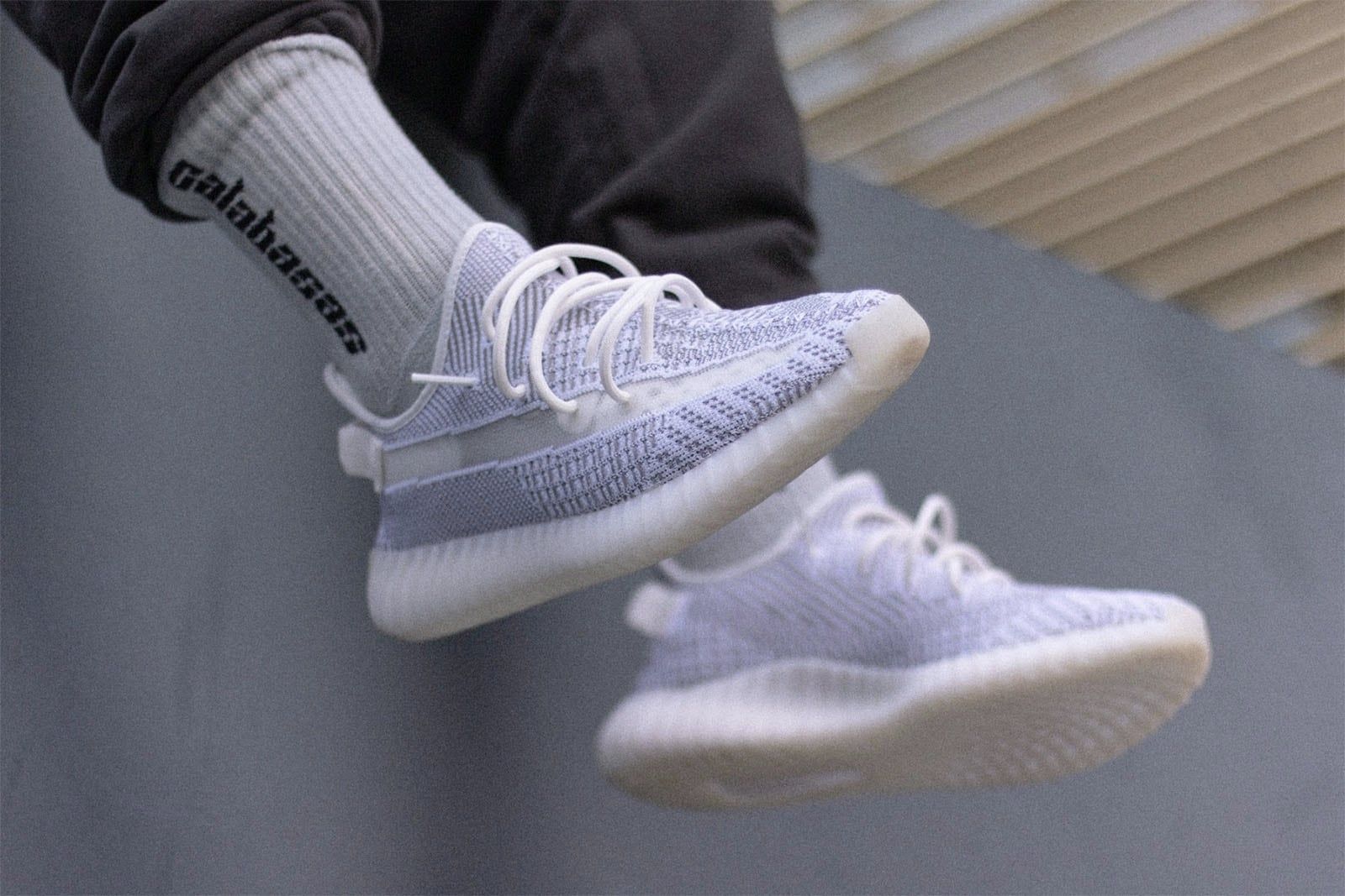 Blue Tint wore SPLY-350 in red. A year later, Static wiped the stripe clear.. Static on foot with Calabasas socks, legs dangling over a grey wall, Sep 2018.