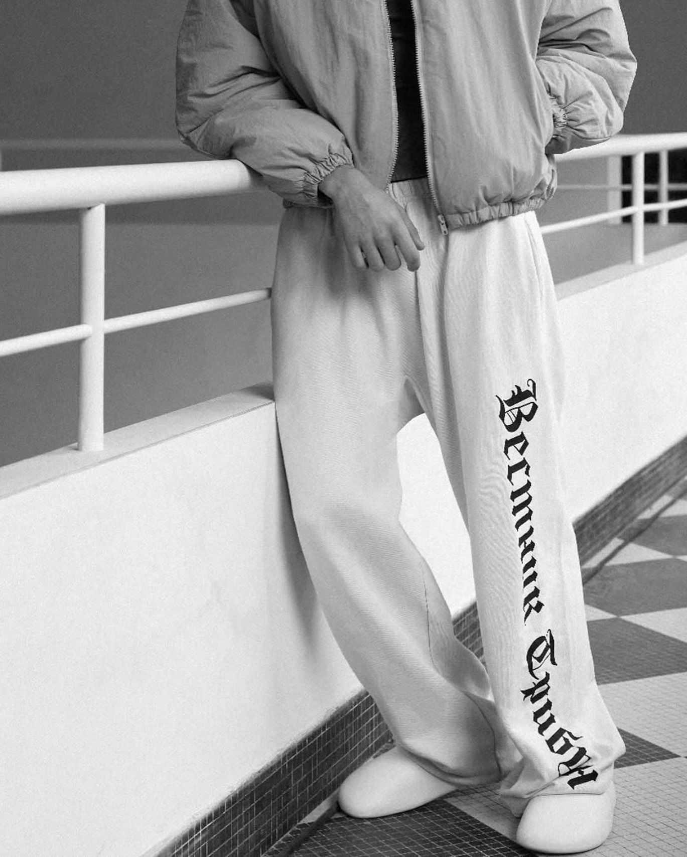 YZY also sold the Tribune sweats with the newspaper taken off. The SP-01 on a model, white, printed down the leg, with a pale nylon jacket: YZY's December 2024 campaign.