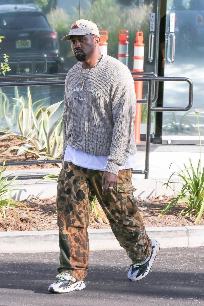 Ye’s Calabasas runner had Complex doubting it was adidas. It was the Wave Runner. Wave Runner colourway on Ye, full length, Comme des Garçons Homme sweater, camo cargos and a cap, near the Yeezy office in Calabasas, June 2017, five months before pairs shipped.
