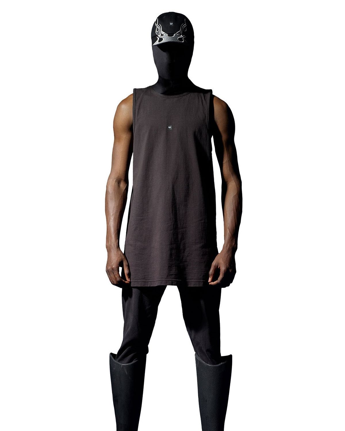 Yeezy Gap Engineered by Balenciaga paused for Uvalde, then put all 25 looks on sale. Black, Loose Tank Top on a man, cropped in.